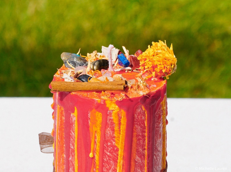 Top of Lammas pillar candle decorated with crystals and herbs