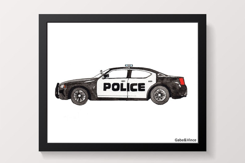 May include: A framed watercolour print of a black and white police car. The word "POLICE" is displayed on the side. The artwork is set against a white background and framed in black. The artist's name, "Gabe&Vince", is in the bottom right corner.