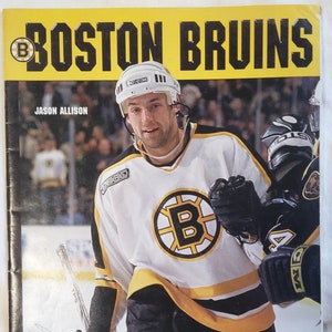 Könnte beinhalten: Ein schwarz-gelbes Programm für ein Hockey-Spiel der Boston Bruins aus der Saison 2000/2001. Das Programm zeigt ein Foto von Jason Allison, einem Bruins-Spieler, der ein weißes Trikot mit schwarzen und gelben Streifen trägt. Das Programm enthält auch den Text "Good Guys Great Game".