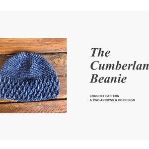 Puede incluir: Un gorro de punto azul con un patrón de puntada texturizado. El gorro está sobre una superficie de madera. El texto "The Cumberland Beanie" y "Crochet Pattern A Two Arrows & Co Design" es visible.