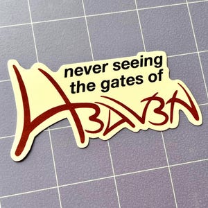 Puede incluir: Una pegatina con el texto "never seeing the gates of Azkaban" en una fuente estilizada. La pegatina tiene un fondo color crema con letras rojo oscuro y un contorno negro. La pegatina est&aacute; sobre una superficie gris claro.