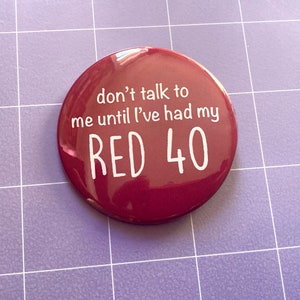 May include: A red button with white text that reads "don't talk to me until I've had my RED 40".