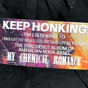 May include: Rectangular sticker with the text "KEEP HONKING!" and "I'M LISTENING TO" above the text "I BROUGHT YOU MY BULLETS, YOU BROUGHT ME YOUR LOVE". The sticker also says "THE 2002 DEBUT ALBUM OF AMERICAN ROCK BAND MY CHEMICAL ROMANCE".