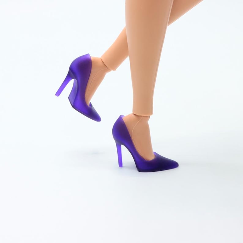 Pu&ograve; includere: Un paio di scarpe con tacco alto di colore viola con punta a punta.