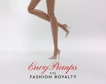 May include: A pair of nude-colored high heels with a stiletto heel. The shoes are called "Envy Pumps" and fit "Fashion Royalty" dolls.