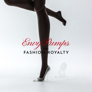 May include: A pair of clear glass high-heeled shoes. The shoes are on a white surface. The text "Envy Pumps Fits Fashion Royalty" is visible in the image.