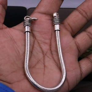 K&ouml;nnte beinhalten: Ein silbernes Schlangenkettenarmband mit strukturierter Oberfl&auml;che. Das Armband hat einen Verschluss.