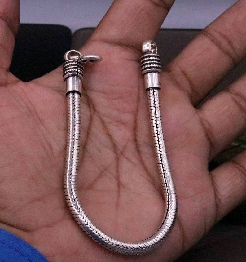 K&ouml;nnte beinhalten: Ein silbernes Schlangenkettenarmband mit strukturierter Oberfl&auml;che. Das Armband hat einen Verschluss.