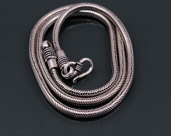 Può includere: Una collana a catena di serpente in argento con chiusura a moschettone.