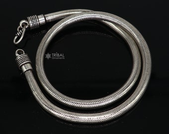 Può includere: Una collana a catena di serpente d'argento con finitura testurizzata. La catena è lunga circa 50 cm e ha una chiusura sicura.