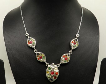 May include: A silver necklace with a pendant featuring a cluster of colorful gemstones in a teardrop shape. The necklace has two smaller teardrop-shaped pendants with gemstones on either side of the larger pendant.