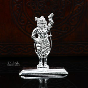 May include: Silver figurine of a standing figure with a crown and a rope in their hand. The figure is standing on a silver base.