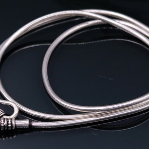 May include: A silver chain necklace with a hook clasp. The chain is made of a thin, round wire and has a smooth, polished finish.