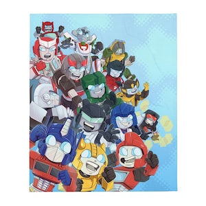 May include: A soft, light blue blanket featuring a colorful illustration of various cartoon robots. The robots are in different colors, including red, blue, yellow, green, and black, with white accents. The blanket has a light blue background with a repeating pattern.
