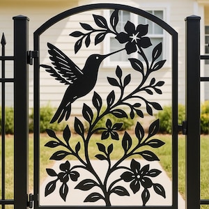 May include: Black metal gate featuring a hummingbird silhouette feeding on a flower, surrounded by leaves and blossoms. The gate has an arched top and is set between two black posts. The design is a decorative garden element.