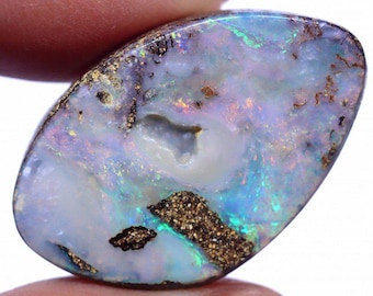 May include: A polished opal gemstone with a mix of colors, including blue, green, and purple. The stone has a unique pattern with areas of white and brown matrix. The opal is oval-shaped and appears to be a cabochon.