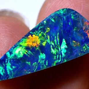 May include: A vibrant, iridescent opal gemstone with a teardrop shape. The opal displays a range of colors, including blue, green, yellow, and orange.
