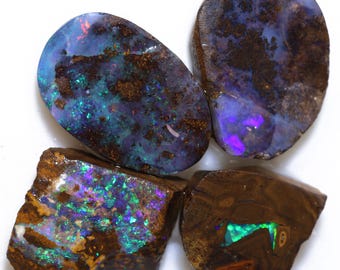May include: Four raw opal stones with vibrant colors. The opals display a mix of blues, greens, purples, and browns. Each stone has a unique shape and pattern, showcasing the natural beauty of the gemstones.