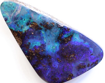 Puede incluir: Una piedra preciosa de ópalo pulido con forma triangular. La piedra muestra una vibrante mezcla de colores, incluyendo azules profundos, púrpuras y verdes, con áreas de matriz marrón. La superficie tiene un acabado brillante, mostrando el juego de color.