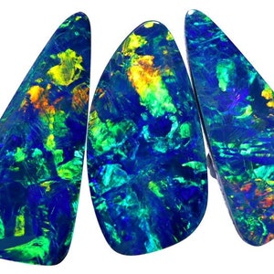 May include: Three iridescent blue, green, and yellow opals with a black background. The opals are shaped like teardrops and have a rough, textured surface.