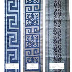 May include: Three decorative fabric ribbons with geometric patterns. The first ribbon is blue and white with a Greek key design, 3 1/2 inches wide. The second ribbon is blue and white with a floral and square design, 4 inches wide. The third ribbon is blue and gray with a circular design, 4 3/4 inches wide.