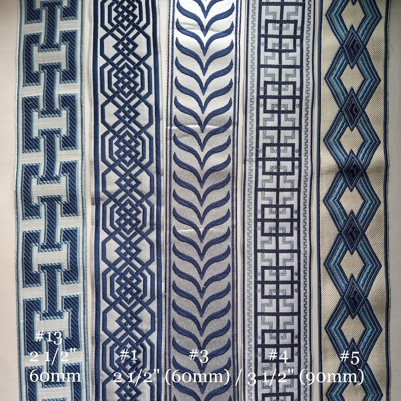 May include: Close-up of five decorative fabric trims with geometric and floral patterns in shades of blue and white. The trims vary in width, with measurements of 2 1/2 inches (60mm) and 3 1/2 inches (90mm) visible. The trims are labeled with numbers.