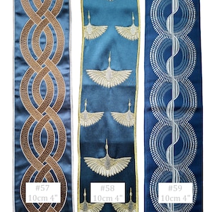 May include: Three decorative ribbons in shades of blue. The first features a brown interwoven design. The second has a pattern of gold birds. The third has a silver circular pattern. Each ribbon is 4 inches wide, with the text "#57", "#58", and "#59".