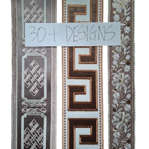 May include: Three vertical strips of decorative fabric trim featuring embroidered patterns. The left strip has a mauve background with geometric knot motifs. The center strip displays a brown and white Greek key pattern. The right strip features white floral embroidery on a mauve background. A white label with the text 30+ DESIGNS is overlaid across the center.