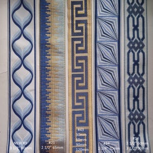 May include: A collection of decorative ribbons in various blue and gold patterns. Designs include geometric shapes, Greek key, and stylized floral motifs. Widths range from 2 1/2 inches to 3 1/2 inches. The image includes text labels with product numbers and measurements.