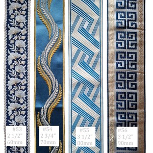 May include: Four decorative ribbons with intricate designs. The ribbons are in shades of blue, white, and gold. The first ribbon has a floral pattern, the second has a feather design, the third has a geometric pattern, and the fourth has a Greek key design. Measurements are included.
