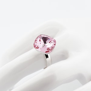 Puede incluir: Un anillo de plata con un gran cristal rosa claro de forma cuadrada.