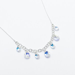 Puede incluir: Un collar de cadena de plata con m&uacute;ltiples colgantes de cristal transparente en forma de l&aacute;grima.