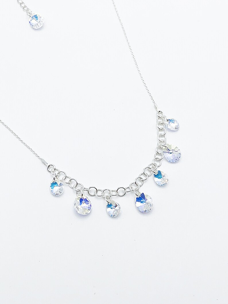 Puede incluir: Un collar de cadena de plata con m&uacute;ltiples colgantes de cristal transparente en forma de l&aacute;grima.