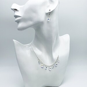 Puede incluir: Un collar de plata con una cadena delicada y gotas de cristal colgantes. Tambi&eacute;n se incluyen pendientes a juego con gotas de cristal.