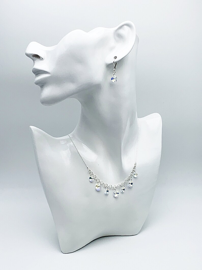 Puede incluir: Un collar de plata con una cadena delicada y gotas de cristal colgantes. Tambi&eacute;n se incluyen pendientes a juego con gotas de cristal.