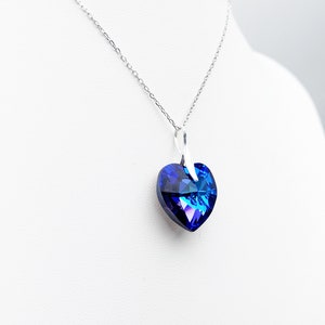May include: A silver chain necklace with a blue crystal heart pendant.