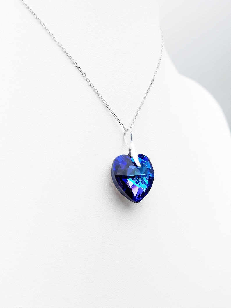 May include: A silver chain necklace with a blue crystal heart pendant.