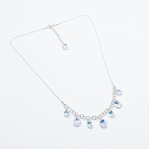 Puede incluir: Un collar de cadena de plata con un cierre de plata y m&uacute;ltiples colgantes de cristal transparente.