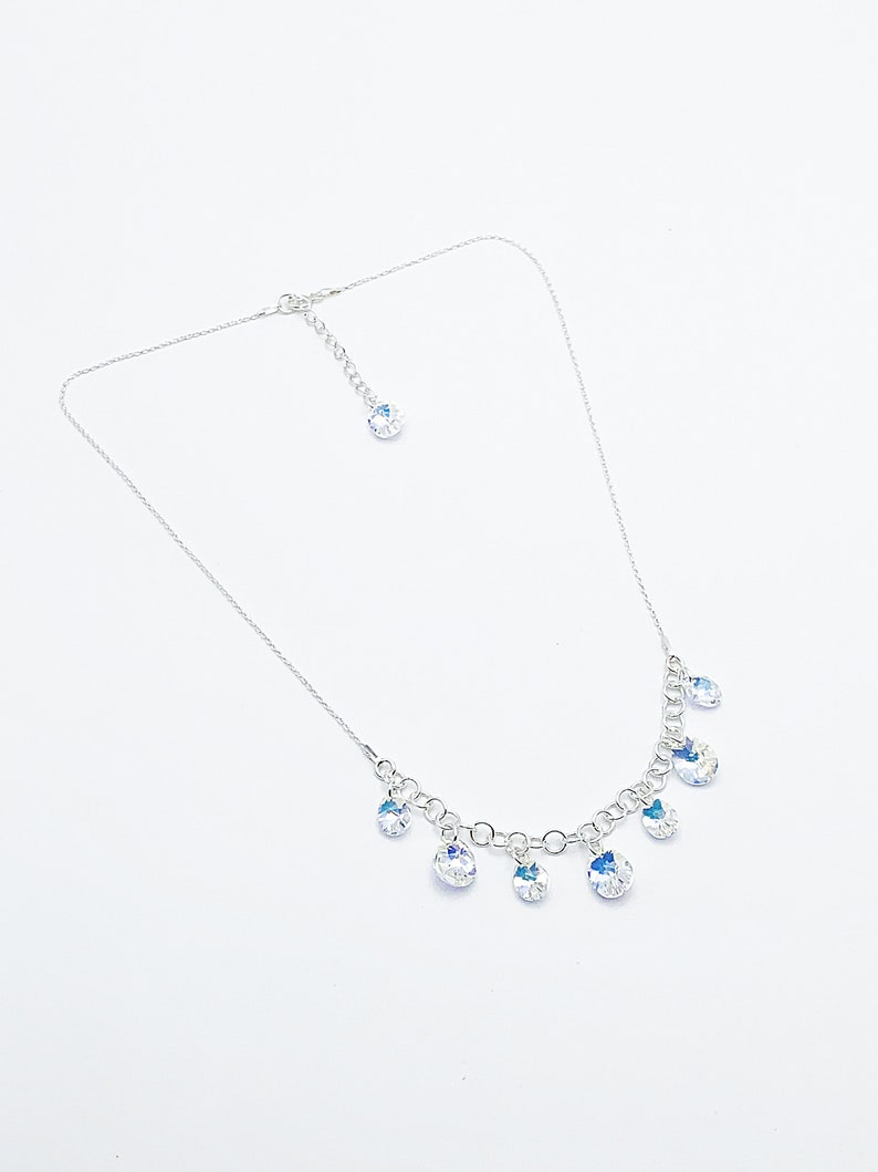 Puede incluir: Un collar de cadena de plata con un cierre de plata y m&uacute;ltiples colgantes de cristal transparente.