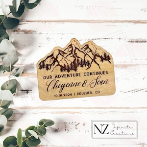 May include: Wooden sign with a mountain range design and the text "Our Adventure Continues Cheyenne & Sean 10.01.2024 | Boulder, CO"
