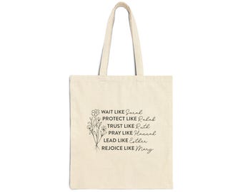 May include: A beige canvas tote bag featuring a black line art illustration of a wildflower bouquet and the text: WAIT LIKE Sarah, PROTECT LIKE Rahab, TRUST LIKE Ruth, PRAY LIKE Hannah, LEAD LIKE Esther, REJOICE LIKE Mary, printed in black ink.