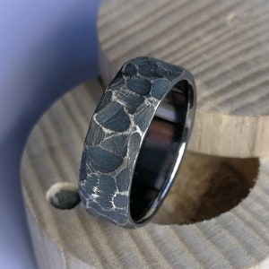 Anillo de plata oxidada con revestimiento de titanio. Facetas ásperas. Hecho a mano y personalizable.