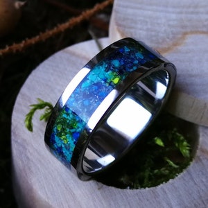 May include: A silver ring with a blue and green epoxy inlay. The ring is in a wooden ring box.