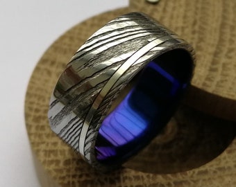 Custom anodized titanium and damascus steel ring with sterling silver / solid gold channel.