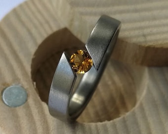 Titanium tension ring with round brilliant cut stone setting. Brushed finish. Handmade and customizable.