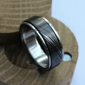 Stainless Damascus Steel and titanium spinner ring. Handmade and customizable.