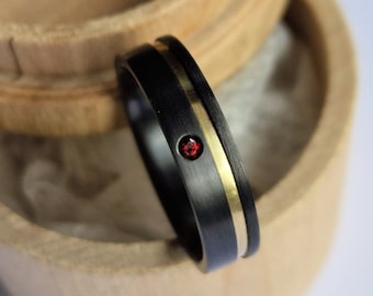 Black zirconium and solid gold band with flush set stone. Two tone finish.