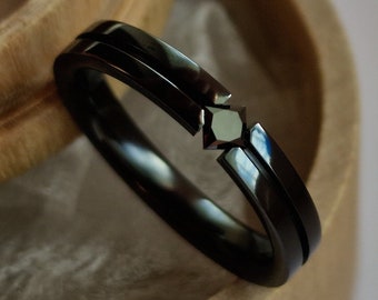 Black zirconium tension ring with princess cut stone setting. Handmade and customizable.