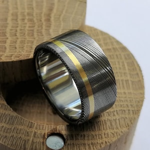 Stainless damascus steel ring with solid gold channel and titanium lining. Handmade and customizable.