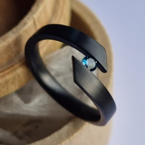 Brushed zirconium tension ring with round brilliant cut stone setting. Handmade and customizable.